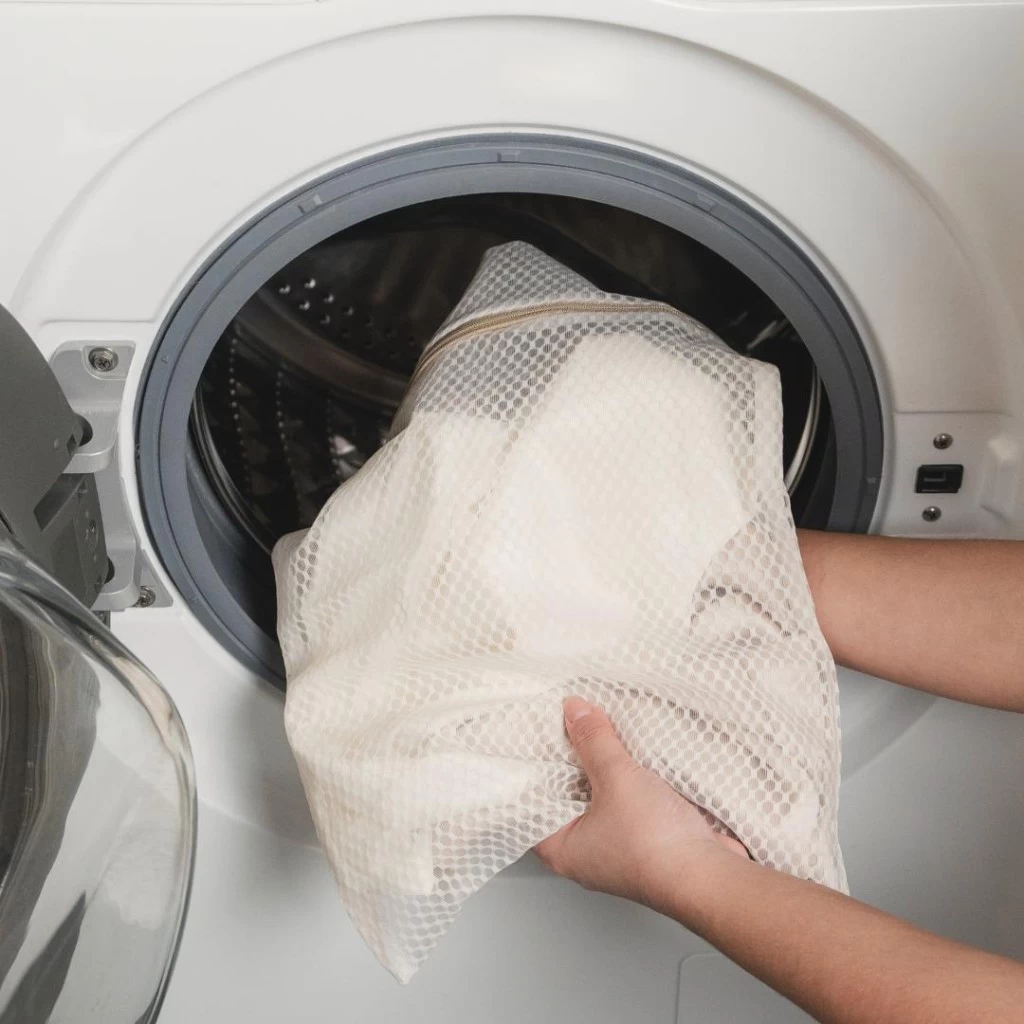 Placing a fine-mesh laundry bag into a front-loading washing machine